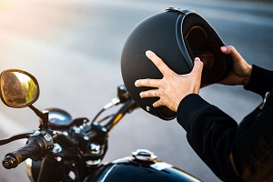 motorcycle driver holding helmet