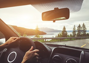 man driving car overlooking lake