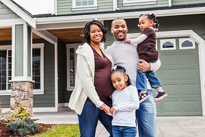 happy family standing outside of their new home